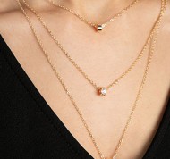 Collana in metallo dorato a tre catene con ciondoli